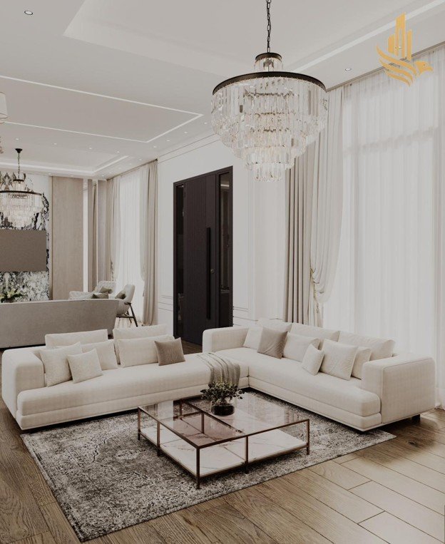 Luxury living room interior designed by a premier interior fit out company in Dubai, featuring a crystal chandelier, custom sectional sofa, and bespoke joinery.